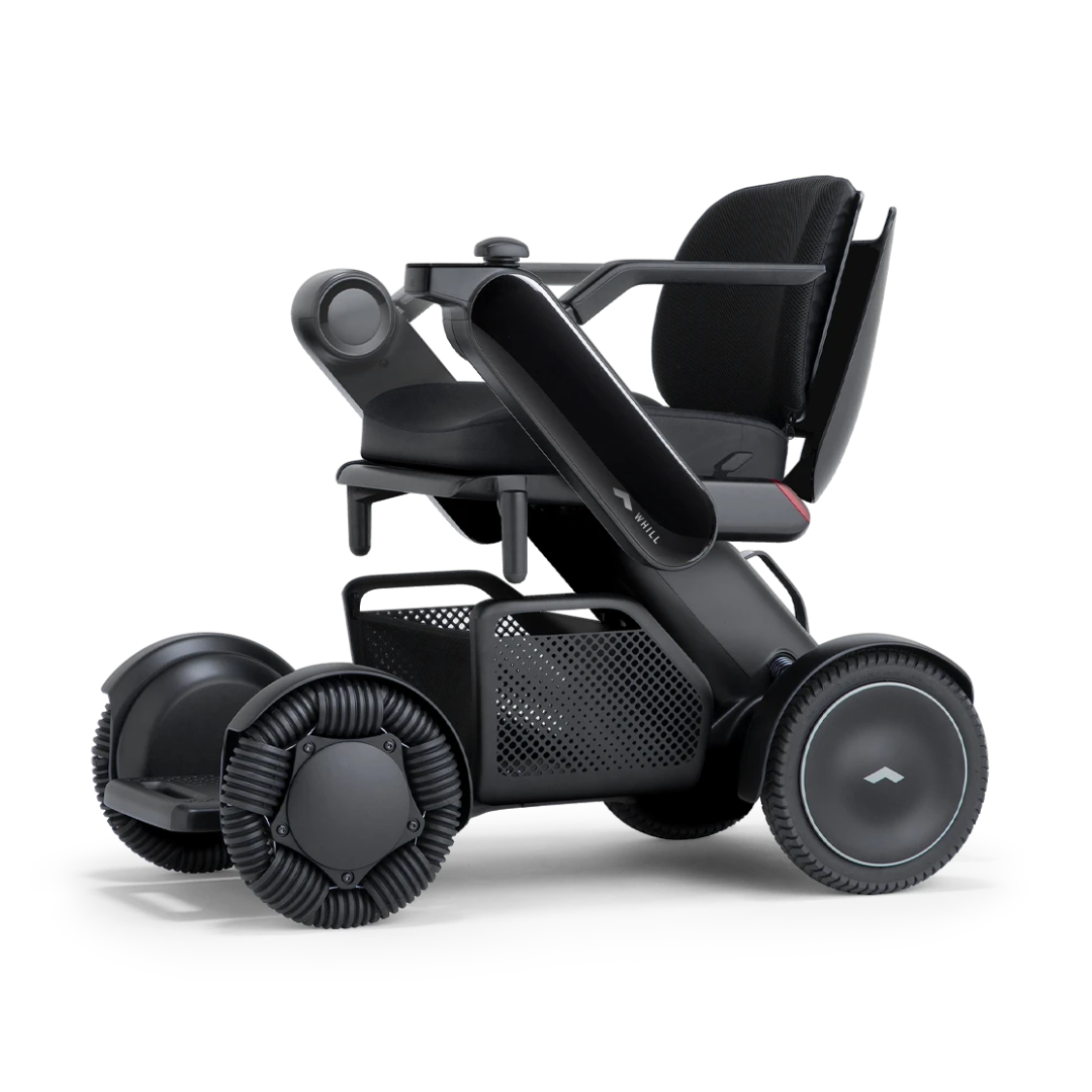 The Whill Model C2 Smart Power Chair is a compact, portable mobility device with four all-terrain wheels, mesh under-seat storage, padded armrests, a minimalist black design, and FDA Class II medical device compliance.